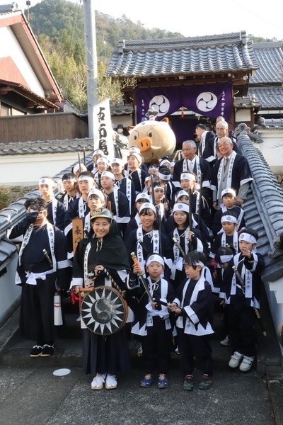 階段に順に並んで衣装を着た子どもたちと市長、まるいのの集合写真