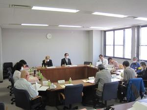 陽の差し込む会議室内で着席し向かい合って座る委員たちの写真