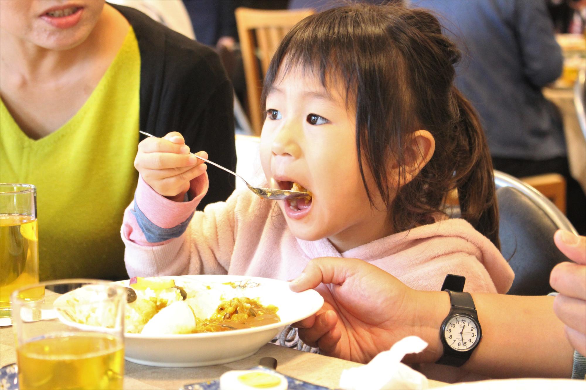 子どもがカレーを食べる様子