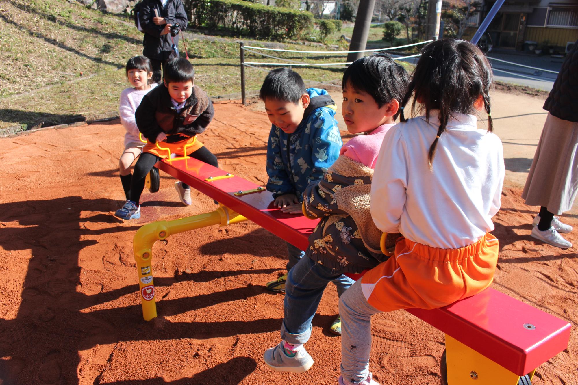 シーソーで遊んでいるこどもたち