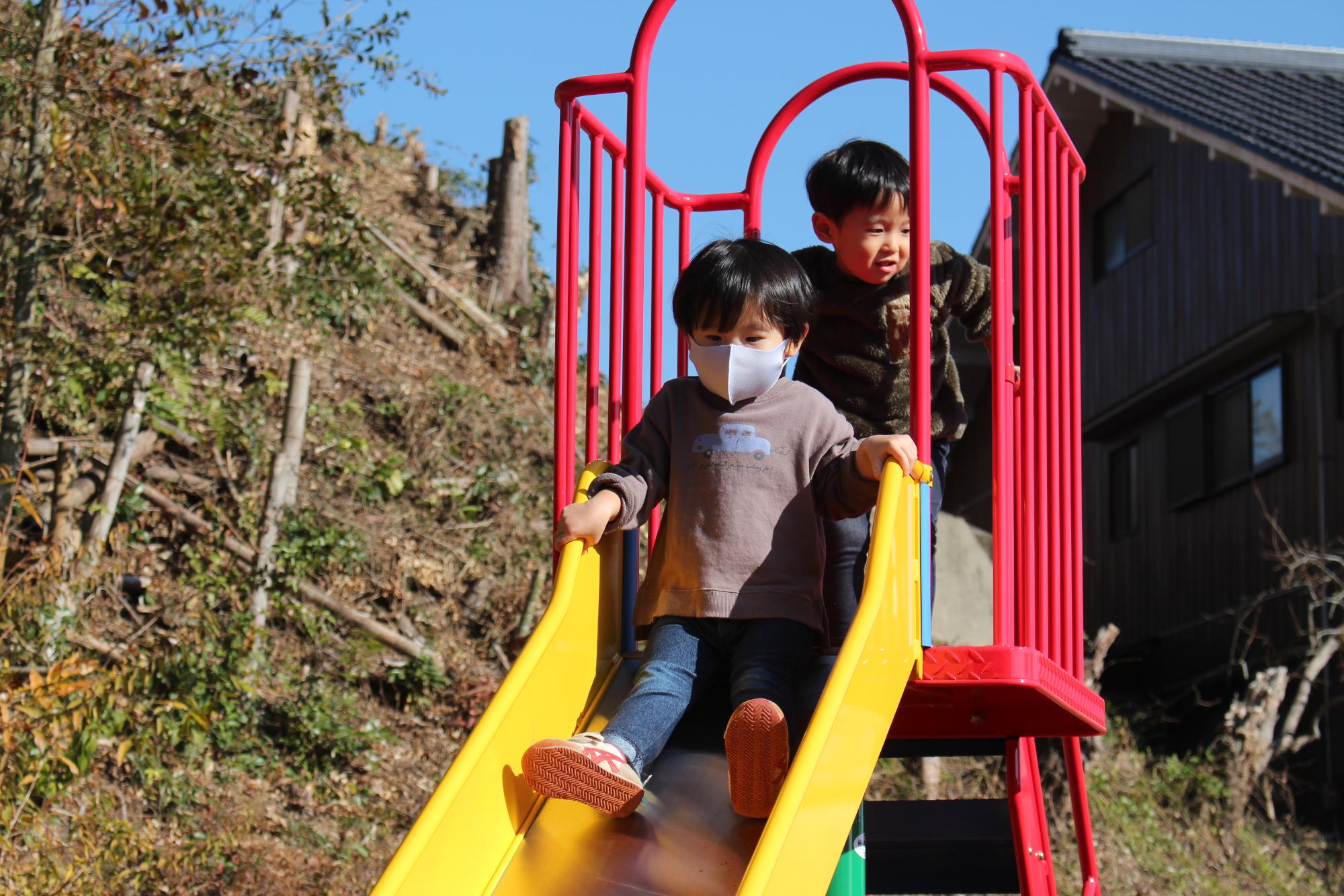 新しいすべりだいで遊ぶこどもたち