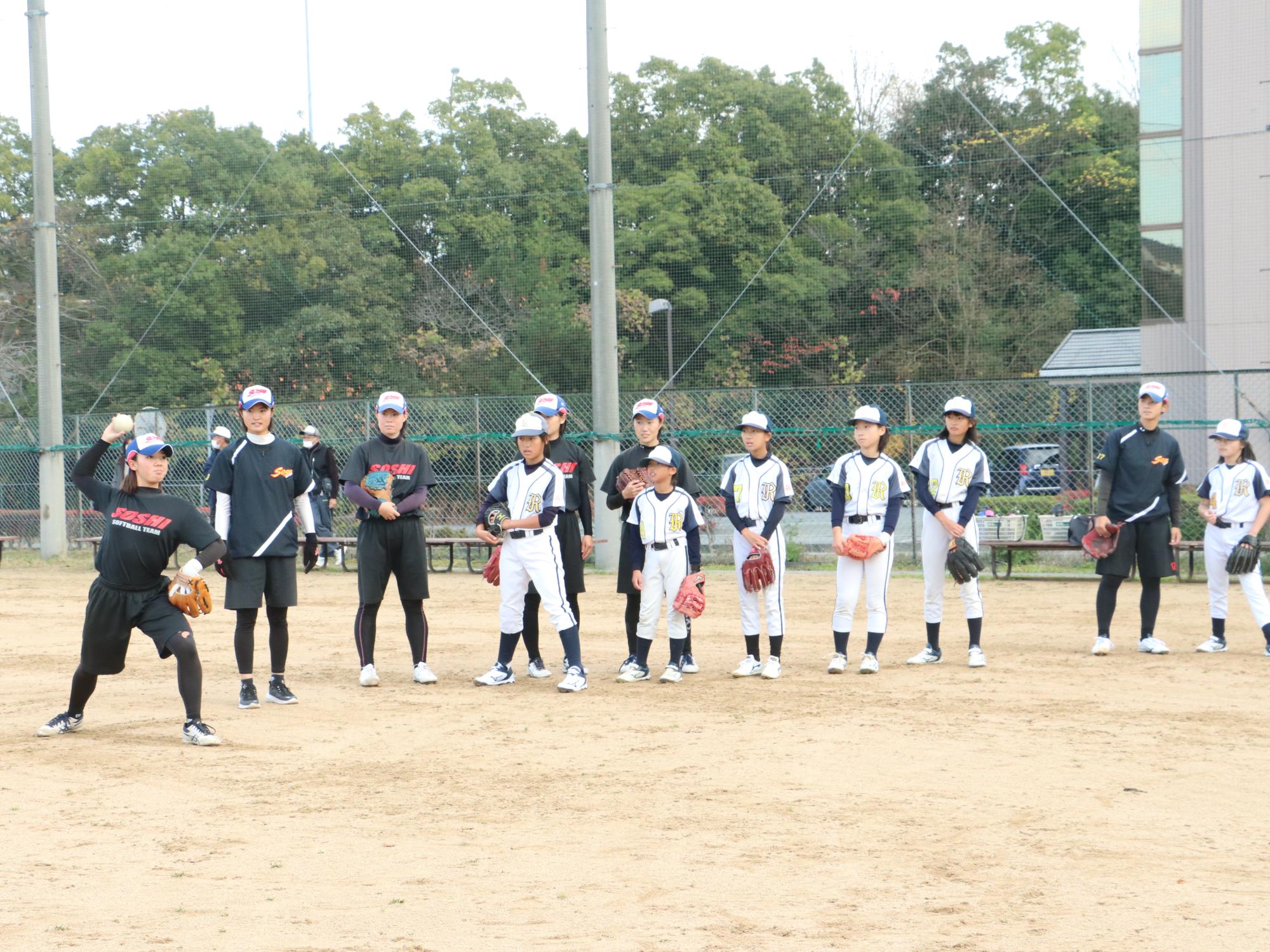 ソフトボールの交流試合でスローイングの指導をされている