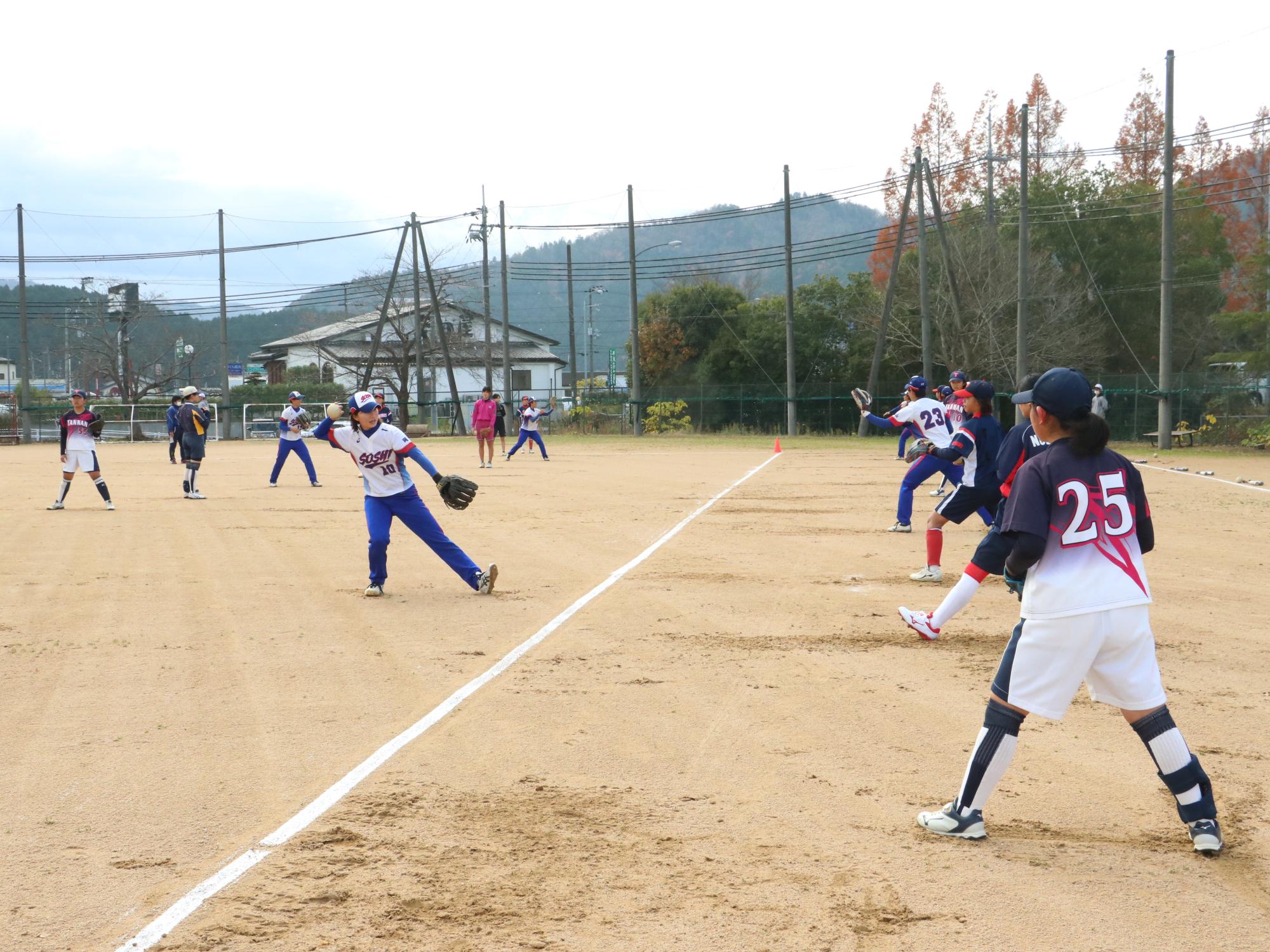 ソフトボールの交流試合でキャッチボールをしている