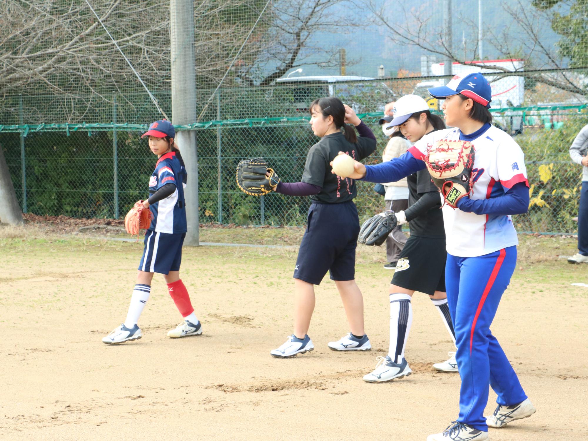 ソフトボールの交流試合でキャッチボールをしている