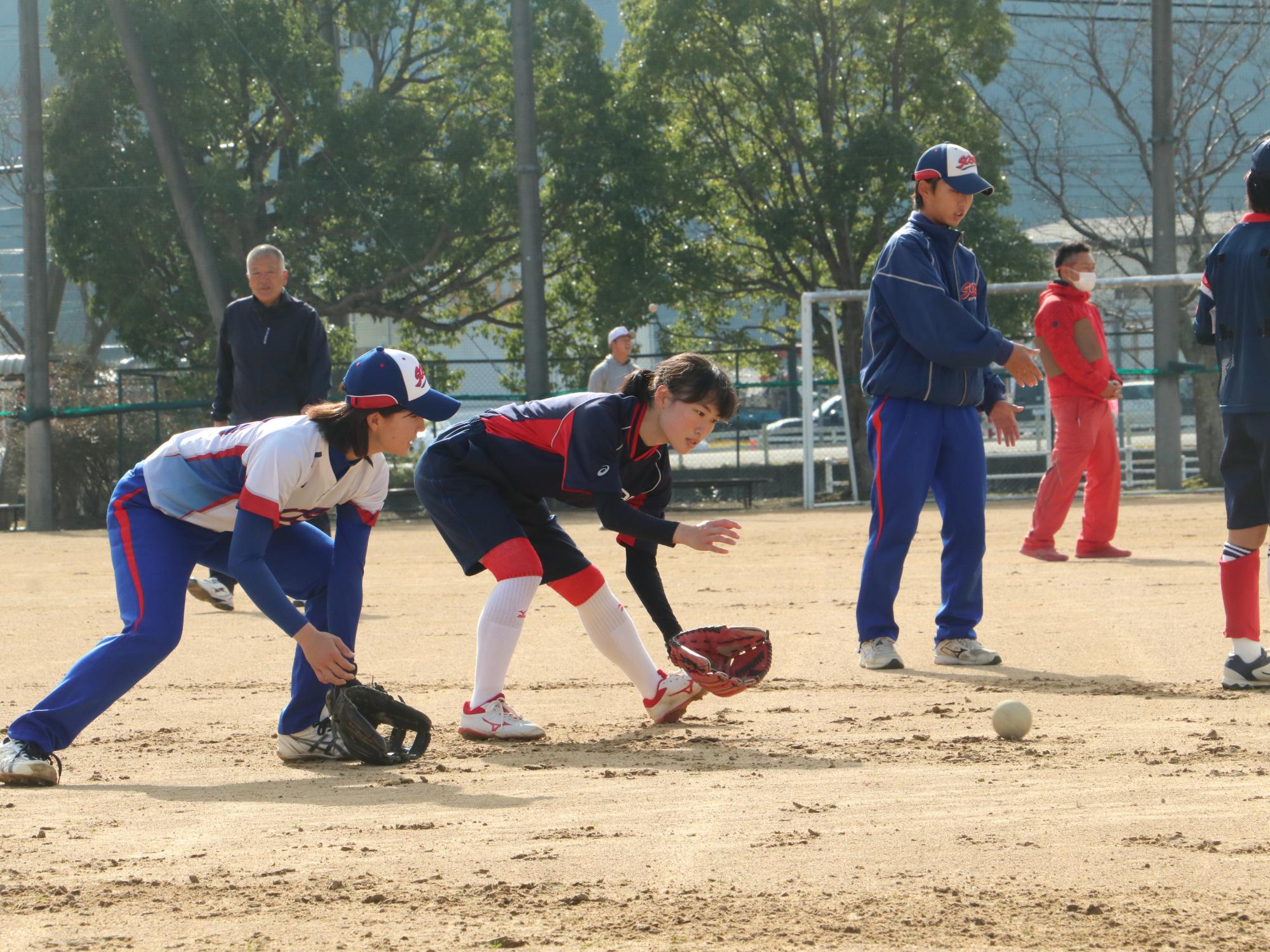 ソフトボールの交流試合でキャッチの練習をしている