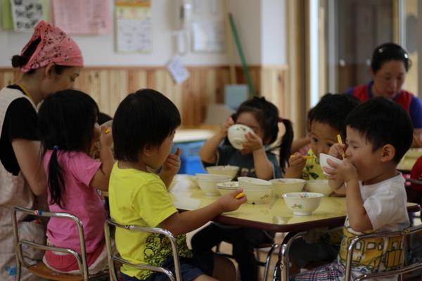 子供たちが美味しそうに給食を食べている写真