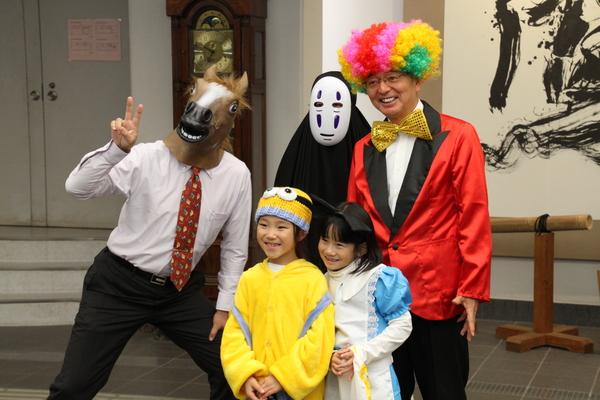 ミニオンズの男の子と水色のパフスリーブのドレスを着た女の子の後ろに馬の被り物をしてピースサインをしている男性、カオナシの横に市長が記念写真を撮影している写真