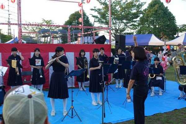 フルートやクラリネットなどの楽器で演奏している子供たちの写真