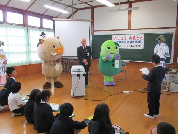 市長を真ん中にしてゆるきゃら2体と白い着物姿で編み笠を被った踊り子2名に向かって男の子が代表で話している写真