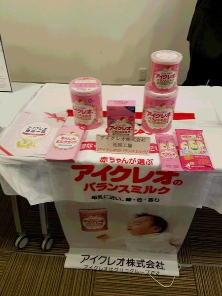 赤ちゃん用の粉ミルク(缶入り・箱入り・スティック状のもの)がパンフレットと一緒に展示されている写真