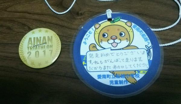 金のメダルとキャラクター人形が載っている手作りのメダルが机に並べられている写真