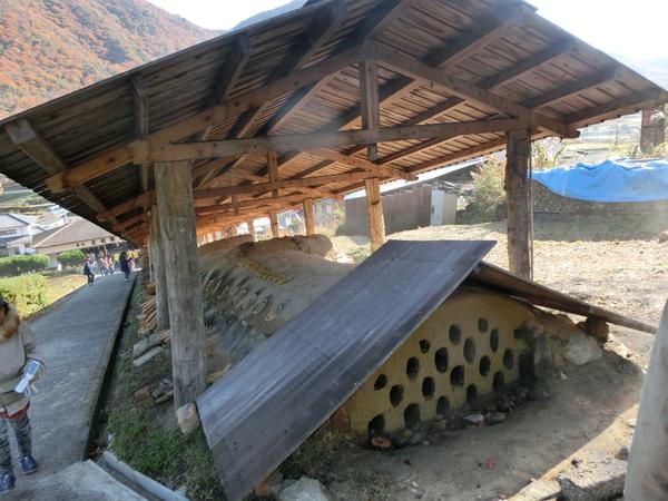 大きな手作りの窯があり、全体に屋根がついている写真