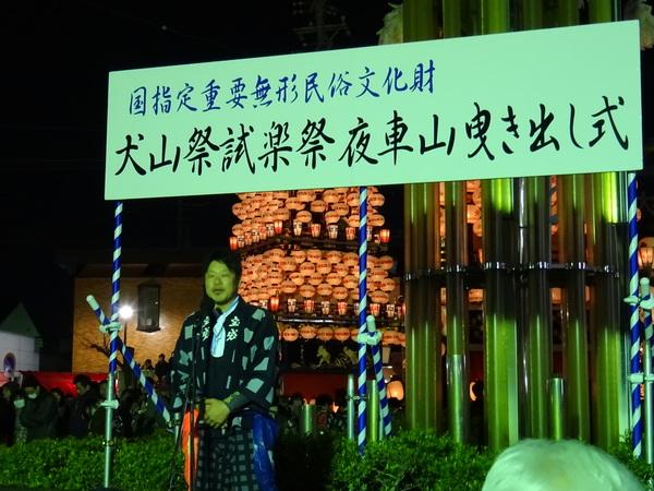 犬山祭試楽祭矢車山曳き出し式と書かれたプラカード看板に書かれた下で男性がお話ししている写真