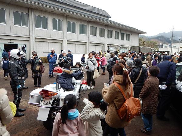 白バイに男の子が乗って周りでは人が集まり写真を撮っている写真