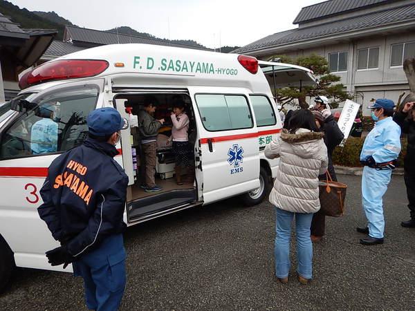 救急車に子供達が乗り込んで中を見ている写真