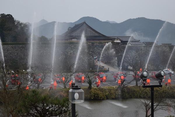 操法の練習で8台の消防車が一斉に放水しています。