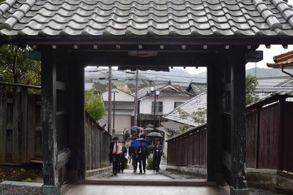 傘をさして城の入口に向かっている人々の写真