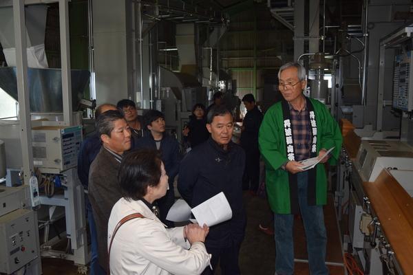 法被姿の男性が質問している女性に答えているのを見ている人々の写真