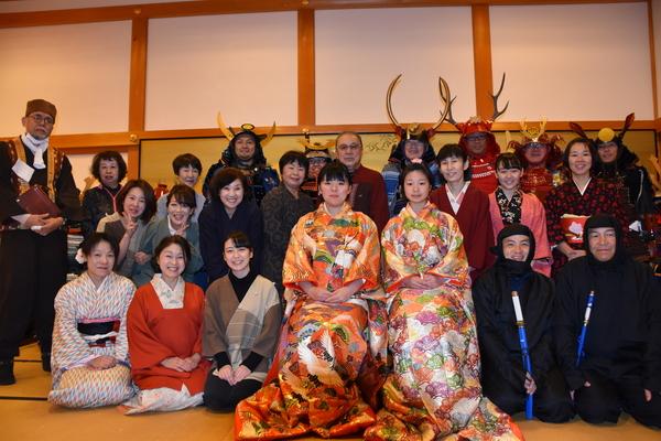 中央には色鮮やかな着物姿の女性が2人いて、その周りに、地味な色の着物を着た女性達や、鎧兜姿の男性や忍者姿の男性達が並んでいる写真