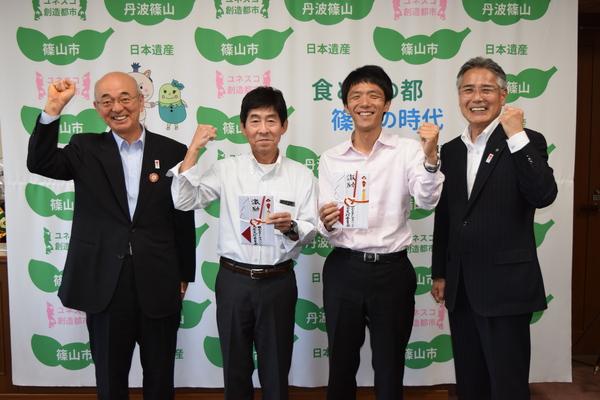 笑顔でガッツポーズをする、市長、山田 幸広さん、安福 直剛さん、スーツを着た男性の写真