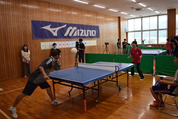 手前の男性と奥側の女性がへディスの試合をしている写真