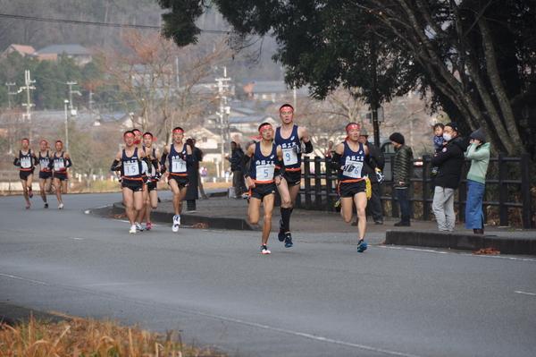 観客が見守る中、必死に走る男子生徒の写真