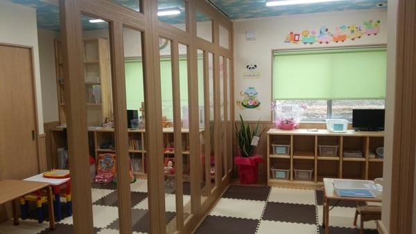 広い部屋を木のフレームで出来たガラスの仕切りで区切った様子の写真