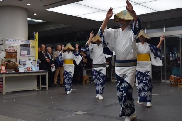 市役所のホールで、編み笠をかぶり、笹の葉の模様が描かれた着物をきた踊り子さん達がデカンショを踊っている様子の写真