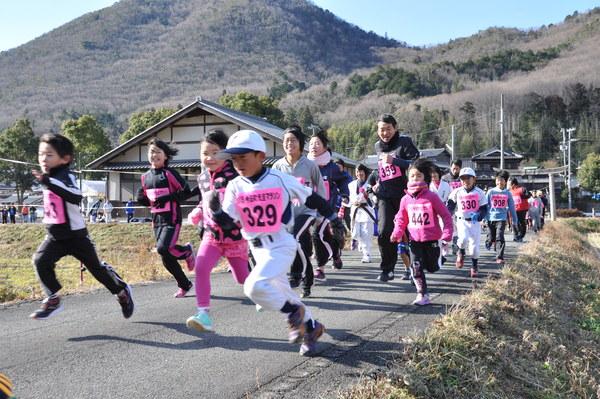 野球部のユニホーム姿やジャージ姿の子供や大人たちがゼッケンをつけてマラソンコースを走っている写真