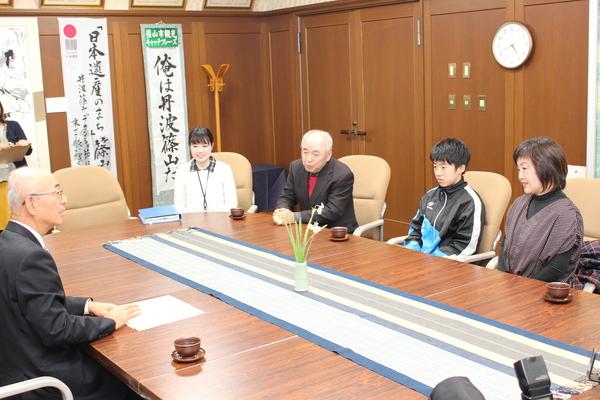 酒井君・祖父・母親・女性職員が市長と向かい合わせに座っている写真