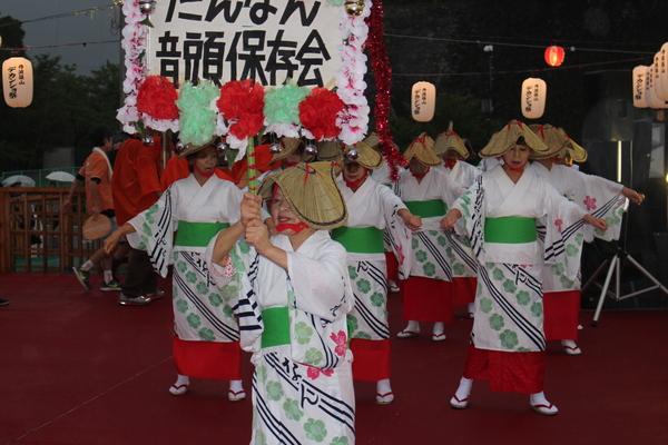 浴衣と編み笠を被った女性たちが躍っている写真