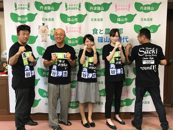 角谷 淳志選手のTシャツを着て笑顔でガッツポーズをしている市長と応援者の写真