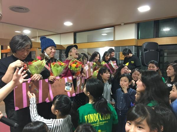 多くの子供達が出演者に花束を渡している写真