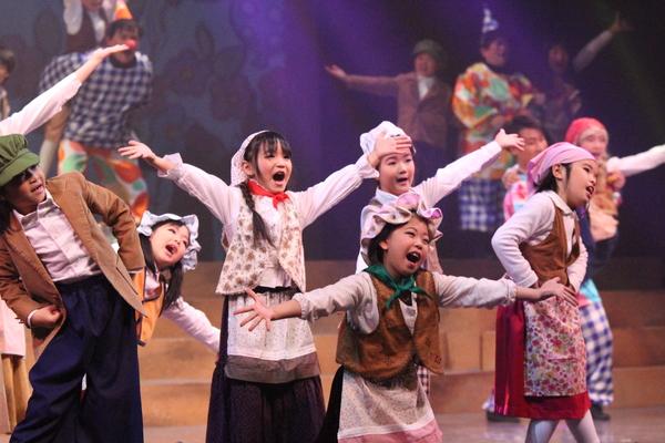 両手いっぱいに手を広げ、歌ってポーズを決める出演者の写真