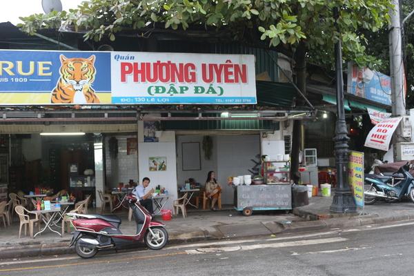 店の外の飲食コーナーで男性が食事をしている写真