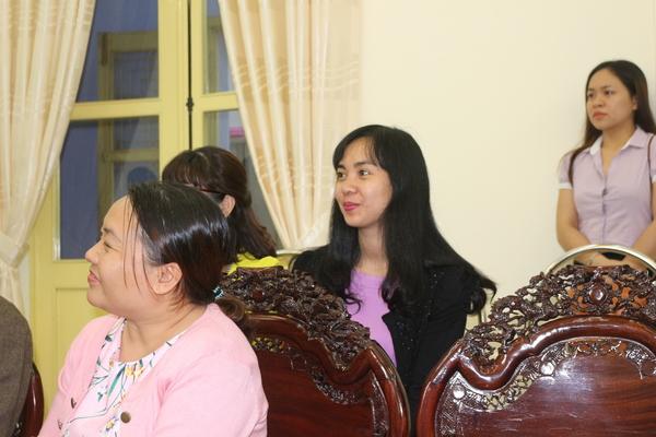 椅子に女性が座って微笑みながら話を聞いている写真