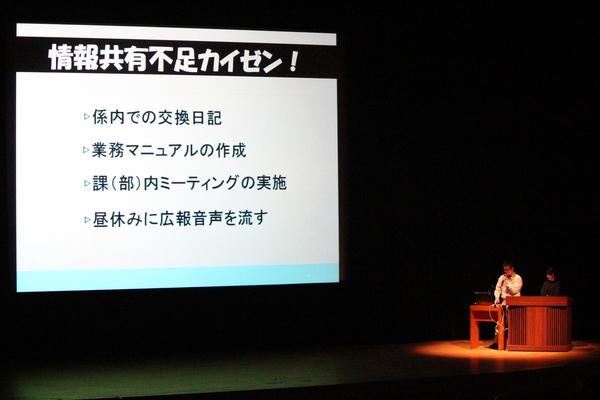 情報共有不足カイゼン案がスクリーンに映され職員が説明している写真