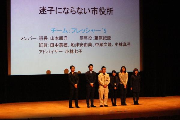 迷子にならない市役所という題名ががスクリーンに映され6名の男女の職員がお話している写真