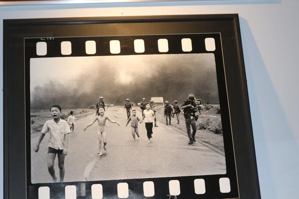 泣きながら逃げる子供たちとその後ろにいる兵士の展示されている白黒写真