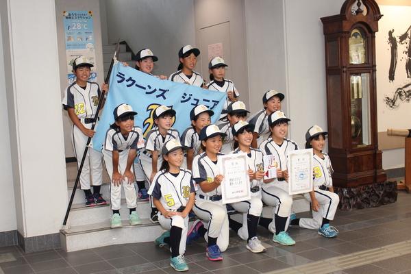 チームの旗を持ち、賞状と、奨励金を手に整列している集合写真