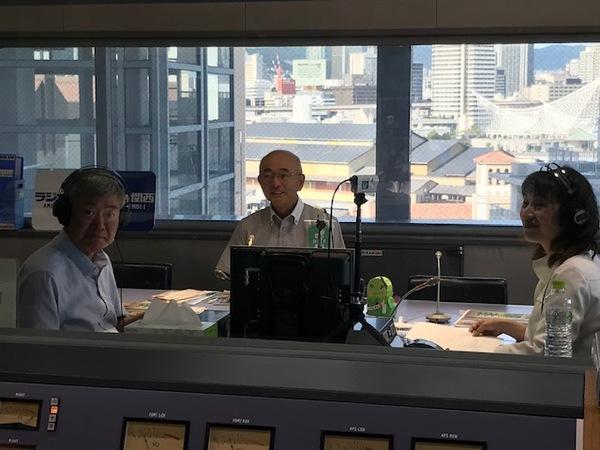 ラジオの収録部屋にいる3人の男女が正面を向いている写真