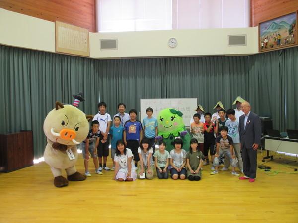 市長とまるいのが子供達をはさみ真ん中にまめりんが並んで一緒に記念写真