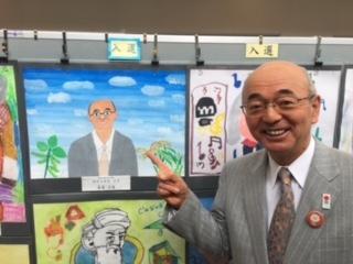 入選に選ばれた市長の似顔絵を市長が嬉しそうに指差ししている写真