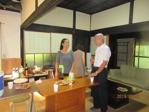 部屋にテーブルとソファがあり、3人の男女が立っている写真