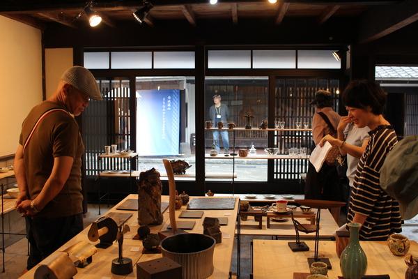 中央には花瓶やコーヒーカップなどの美術品が飾られていて、お客さんが美術品を見ている写真