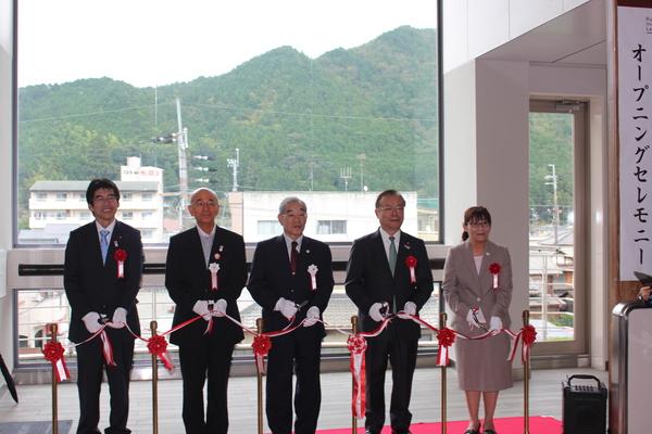 市長と3名のスーツを着た男性と女性が1名並んでいて、ハサミを持って、テープカットをしている写真