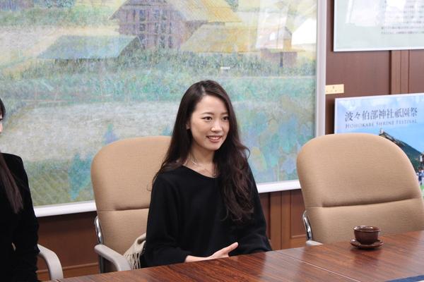 黒く長い髪をした吉田 唯那(ゆいな)さんが椅子に座り笑顔で写っている写真