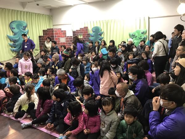 人形劇を見に来ている大人や子供たちの写真