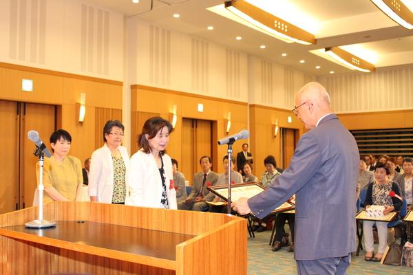 3人の女性グループに賞状を読み上げている市長の写真