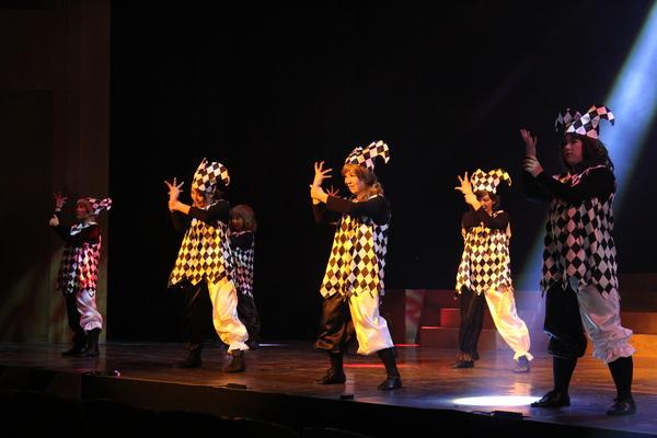 白黒のチェックの服と帽子をかぶり、ポーズを決める6人の女性の写真